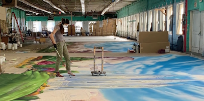 A person working on creating muslin backdrops